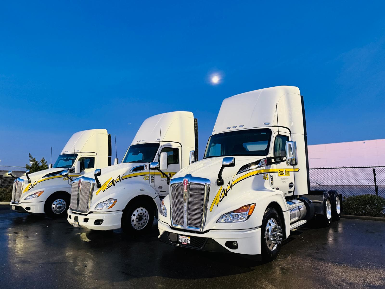 Three washed white Kenworth semi trucks